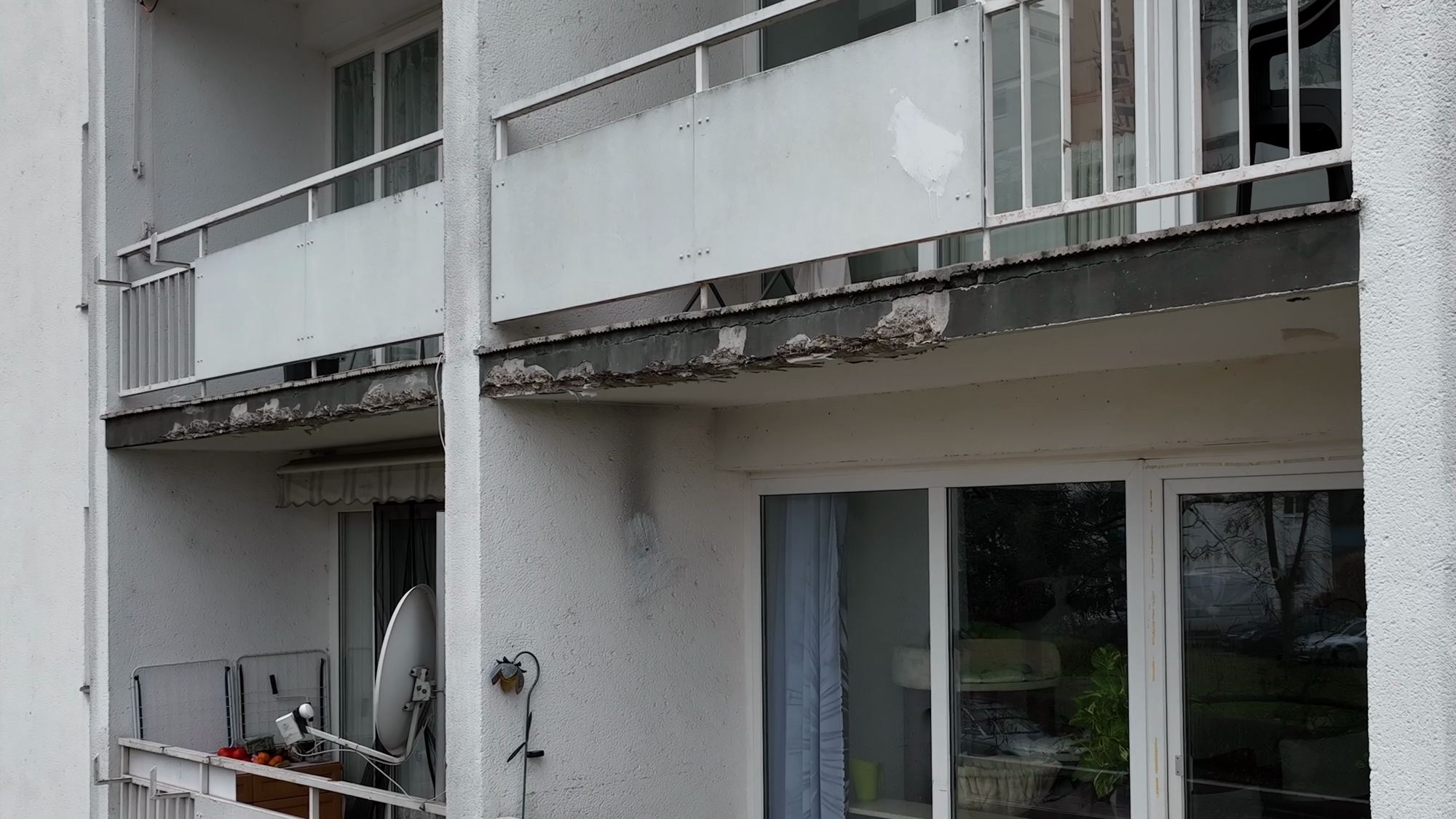 Balkone eines Wohngebäudes, an der Stirnseite einer Balkonplatte ist eine Abplatzung zu erkennen