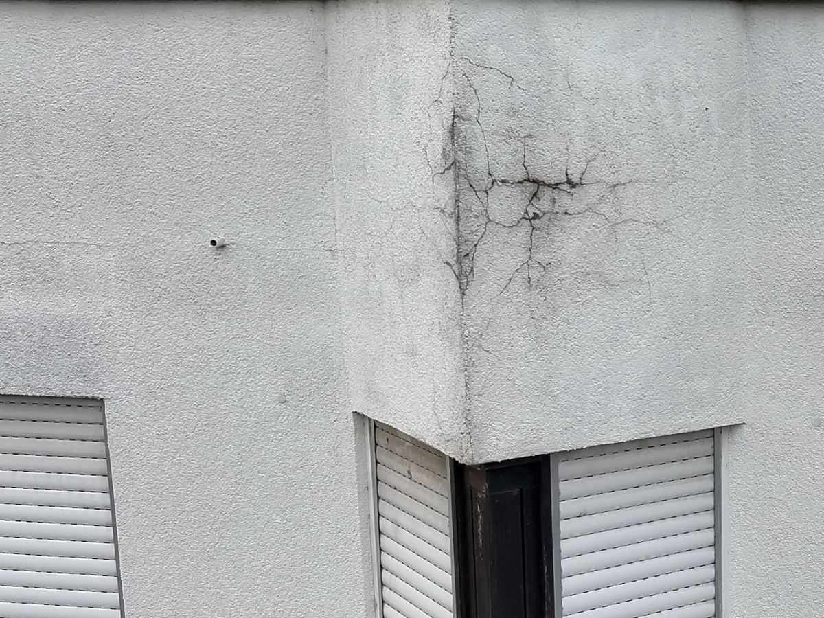 Verzweigtes Rissbild im Putz an einer Gebäudeecke