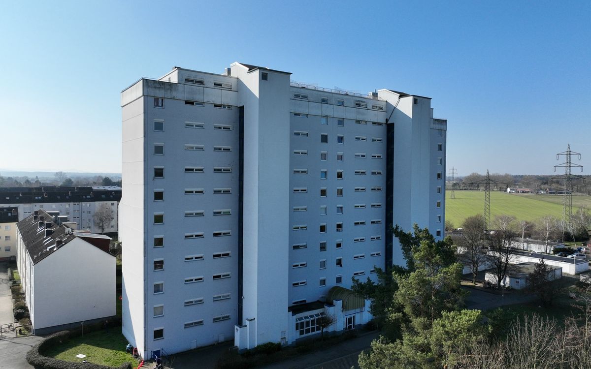 Großes Wohnhochhaus mit 14 Geschossen vor blauem Himmel