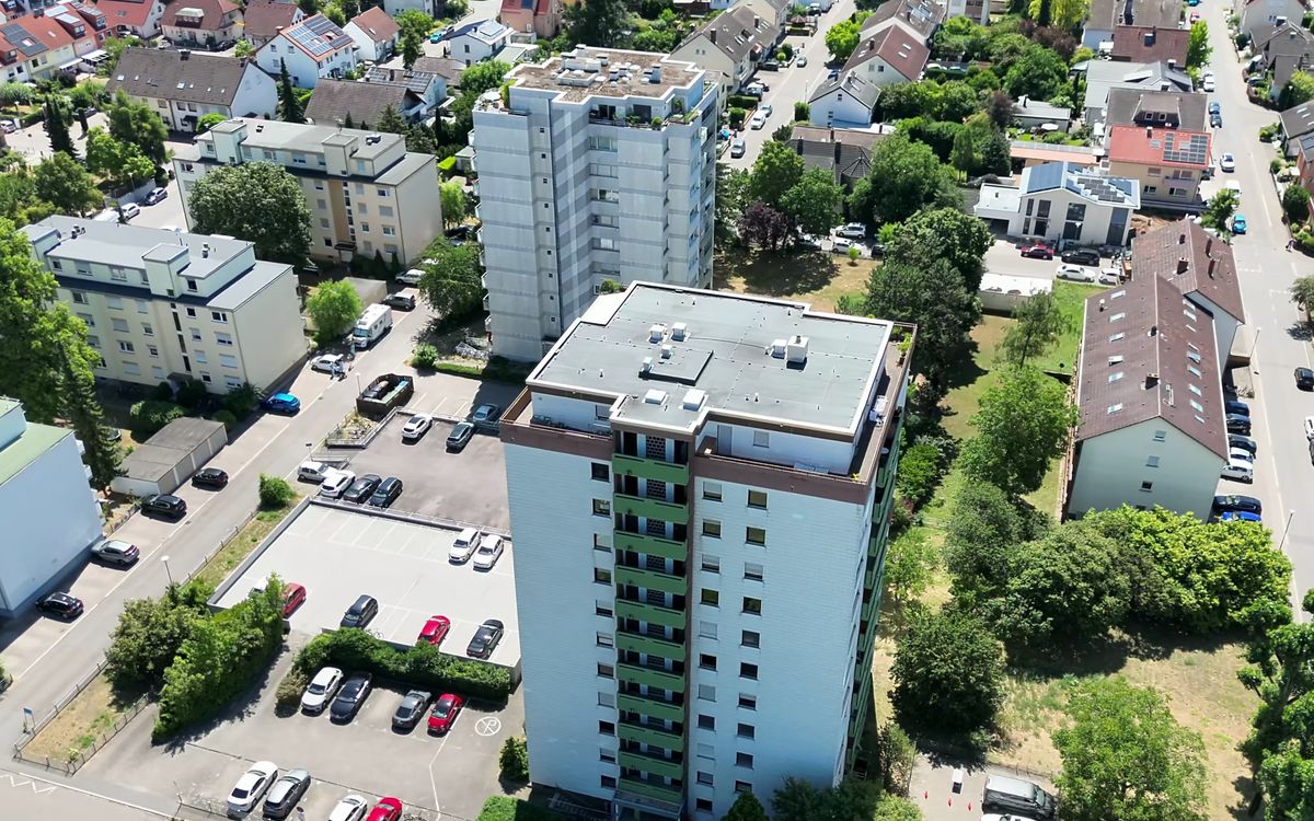 Luftaufnahme eines Wohnhochhauses mit Parkplatz